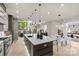 Open concept kitchen with a central island, modern lighting, and adjacent dining and living areas at 624 Heather Ln, Charlotte, NC 28209