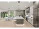 Modern eat-in kitchen features large island with seating, stone countertops, hardwood floors, and stainless appliances. Open floor plan at 624 Heather Ln, Charlotte, NC 28209