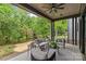 Covered patio with comfortable outdoor seating surrounded by lush greenery at 624 Heather Ln, Charlotte, NC 28209