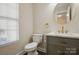 Modern bathroom featuring sleek gray vanity, marble countertop, gold hardware, and a round mirror at 6430 Matlea Ct, Charlotte, NC 28215