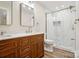 Bathroom featuring wood vanity with double sinks and tiled walk-in shower with glass door at 6430 Matlea Ct, Charlotte, NC 28215