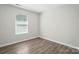 Bright bedroom with window and neutral walls, showcasing the wood flooring at 6430 Matlea Ct, Charlotte, NC 28215