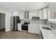 Modern kitchen with stainless steel appliances, white cabinets, gray subway tile backsplash and wood flooring at 6430 Matlea Ct, Charlotte, NC 28215