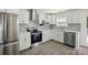 Well-lit modern kitchen with stainless steel appliances, white cabinets, and wood flooring at 6430 Matlea Ct, Charlotte, NC 28215