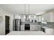 Modern kitchen with an island featuring stainless steel appliances, white cabinets, and stylish lighting at 6430 Matlea Ct, Charlotte, NC 28215