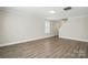 Bright living room featuring wood-look flooring, a large window, and neutral paint at 6430 Matlea Ct, Charlotte, NC 28215