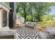 Inviting back deck with outdoor furniture, fireplace, and view of backyard with mature trees at 6719 Woodshed Cir, Charlotte, NC 28270