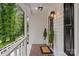 View of the covered front porch with stylish light fixtures and decorative plants at 6719 Woodshed Cir, Charlotte, NC 28270
