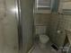 This bathroom features a glass enclosed shower and a standard toilet with patterned tile walls at 6813 Navajo Trl, Sherrills Ford, NC 28673