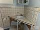 This bathroom features a sink with open storage underneath and patterned tile walls at 6813 Navajo Trl, Sherrills Ford, NC 28673