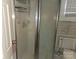 This bathroom features a glass enclosed shower and a standard toilet with textured tile walls at 6813 Navajo Trl, Sherrills Ford, NC 28673