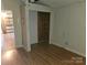 This bedroom features wood-look floors, paneled walls, closet space, and an open doorway to another room at 6813 Navajo Trl, Sherrills Ford, NC 28673