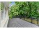 Black wooden deck provides an outdoor space with a lush green tree backdrop at 7016 Wannamaker Ln, Charlotte, NC 28226