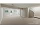 A large open finished basement area with windows and door providing ample natural light and access at 7016 Wannamaker Ln, Charlotte, NC 28226