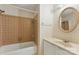 Cozy bathroom with a tiled tub, rounded mirror, and neutral color scheme offers a functional design at 7016 Wannamaker Ln, Charlotte, NC 28226