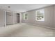 Bedroom boasts open closet and two bright windows, creating a cozy, inviting atmosphere at 7016 Wannamaker Ln, Charlotte, NC 28226