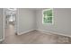 Cozy room with wood-look flooring, neutral paint, and bright window at 7016 Wannamaker Ln, Charlotte, NC 28226