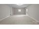 Neutral bedroom features plush carpet, ample light, and space for furniture at 7016 Wannamaker Ln, Charlotte, NC 28226