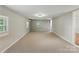 Large bedroom with neutral walls, carpet flooring, a window, and modern lighting at 7016 Wannamaker Ln, Charlotte, NC 28226
