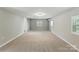 Spacious carpeted bedroom featuring neutral walls, a window, and contemporary lighting at 7016 Wannamaker Ln, Charlotte, NC 28226