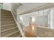 Bright entryway features hardwood floors, staircase, and view into a spacious living area with ample natural light at 7016 Wannamaker Ln, Charlotte, NC 28226