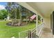 Inviting front porch with white railings and a charming garden featuring a rustic arbor and seating area at 7016 Wannamaker Ln, Charlotte, NC 28226