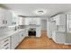 Bright kitchen features white cabinets, modern appliances, and wood-look flooring at 7016 Wannamaker Ln, Charlotte, NC 28226
