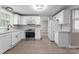 Bright kitchen featuring white cabinets, stainless steel appliances, and wood-look flooring at 7016 Wannamaker Ln, Charlotte, NC 28226