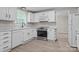 Bright kitchen featuring white cabinets, stainless steel appliances, and wood-look flooring at 7016 Wannamaker Ln, Charlotte, NC 28226