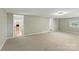 Large living room with neutral walls, carpet flooring, a window, and modern lighting at 7016 Wannamaker Ln, Charlotte, NC 28226