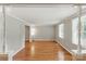 Spacious living room with hardwood floors, neutral paint, and abundant natural light from large windows with blinds at 7016 Wannamaker Ln, Charlotte, NC 28226