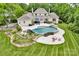 Aerial view of the home's backyard oasis, featuring a custom pool, rock slide, patio, and beautifully landscaped grounds at 8305 Bar Harbor Ln, Charlotte, NC 28210