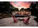 Outdoor living space with patio, fire pit, lounge chairs, pool, lush landscape, and a rock slide feature at 8305 Bar Harbor Ln, Charlotte, NC 28210