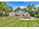 Lush backyard with inviting pool, slide with waterfall, manicured lawn, and relaxing patio area with fire pit at 8305 Bar Harbor Ln, Charlotte, NC 28210
