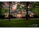 Elegant two-story brick home featuring a lush green lawn, mature trees, and inviting entrance with stately columns at 8305 Bar Harbor Ln, Charlotte, NC 28210