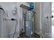 Basement utility area with water heater, pressure tank, and accessible plumbing at 85 Sw Myrtle Sw Ave, Concord, NC 28025