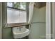 Small vintage bathroom with pedestal sink, frosted window for privacy, and older shower at 85 Sw Myrtle Sw Ave, Concord, NC 28025