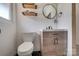 Well-lit bathroom showcasing a vanity, toilet, and unique open shelving at 85 Sw Myrtle Sw Ave, Concord, NC 28025