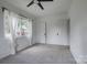 Bright bedroom features a ceiling fan, plush gray carpet, and natural light from a large window at 85 Sw Myrtle Sw Ave, Concord, NC 28025