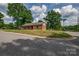 View of a brick home on a corner lot with mature trees and a well-kept lawn at 85 Sw Myrtle Sw Ave, Concord, NC 28025