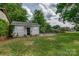 Backyard shed set in a spacious green yard with mature trees and landscaping at 85 Sw Myrtle Sw Ave, Concord, NC 28025