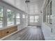 Bright sunroom featuring white paneling, several windows, and durable laminate flooring at 85 Sw Myrtle Sw Ave, Concord, NC 28025