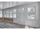 Light-filled sunroom featuring wood paneling, several windows, and durable laminate flooring at 85 Sw Myrtle Sw Ave, Concord, NC 28025