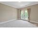 Bedroom with carpeted floors, neutral walls, and French doors leading to a balcony or patio area at 8904 Woodhall Lake Dr, Waxhaw, NC 28173