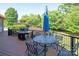Outdoor deck features a grill, dining table with umbrella, and beautiful landscaping at 8904 Woodhall Lake Dr, Waxhaw, NC 28173