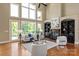 Elegant living room with a fireplace, built-in bookshelves, and soaring ceilings overlooking the backyard at 8904 Woodhall Lake Dr, Waxhaw, NC 28173