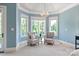 Sitting area in main bedroom with 3 windows, stylish chairs, and a chandelier at 8904 Woodhall Lake Dr, Waxhaw, NC 28173