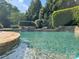 Tranquil pool has stone accents and lush greenery surrounding it at 8904 Woodhall Lake Dr, Waxhaw, NC 28173