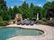 Inviting pool area with comfortable lounge seating and outdoor fireplace in a private backyard at 8904 Woodhall Lake Dr, Waxhaw, NC 28173