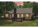 The backyard of this home features a wooden deck and brick chimney at 11701 Brockley Ct, Charlotte, NC 28215
